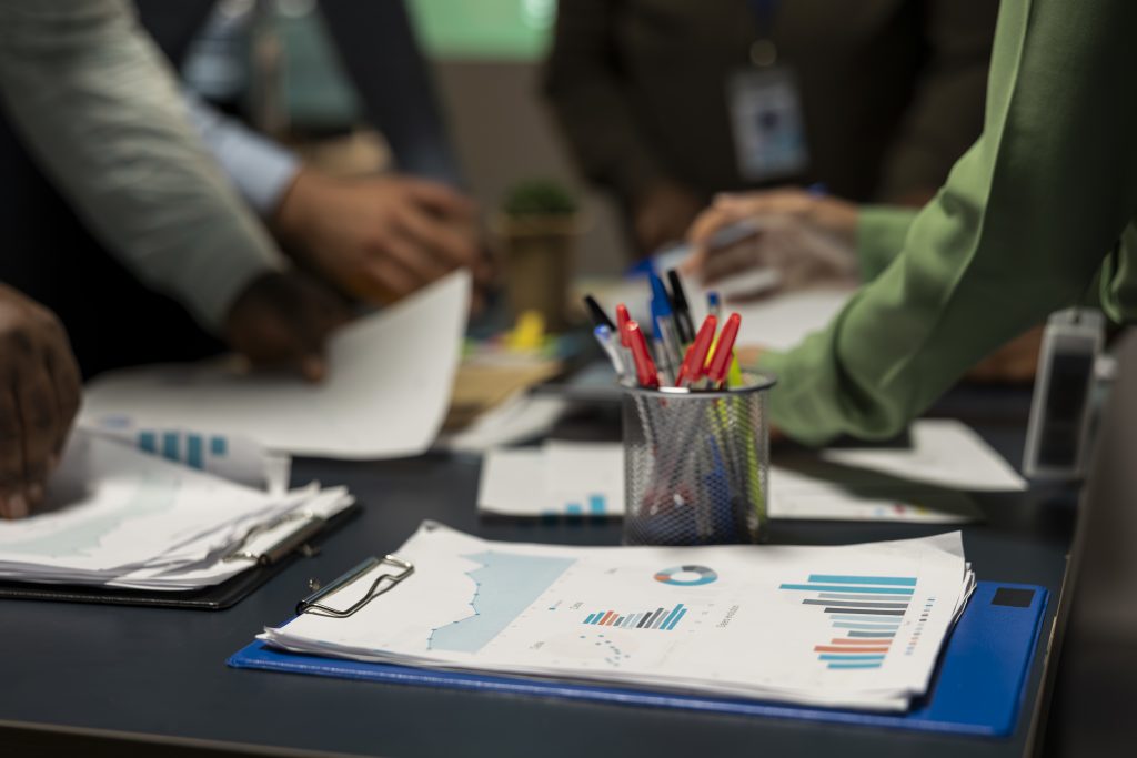 Close up of diverse business team exchanging insights and forecasting diagrams